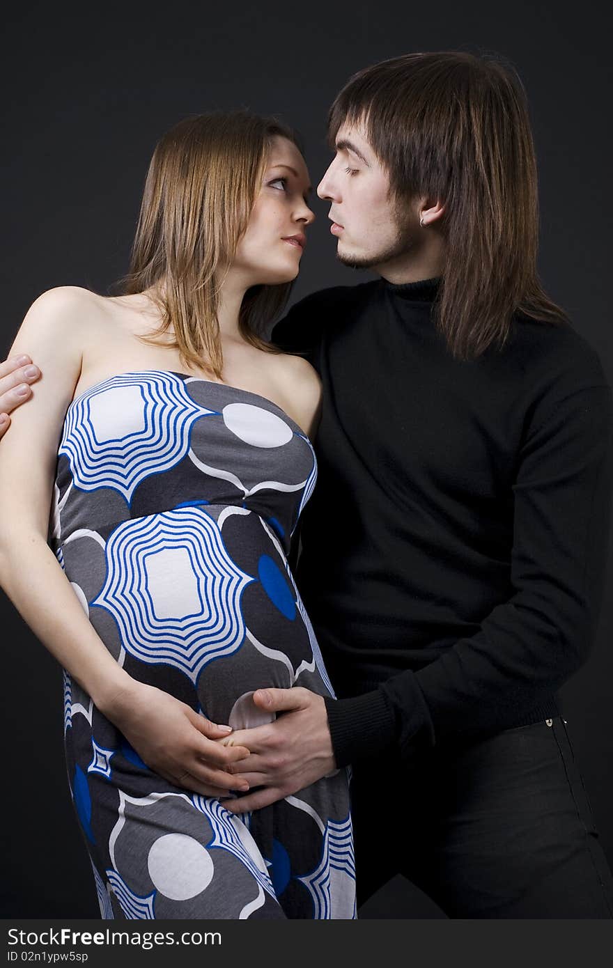 Pregnant couple in loving pose.