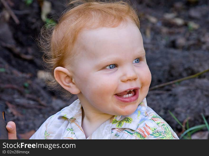 A little boy playing in the yard.