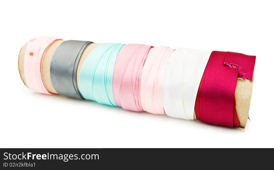 Colorful satin ribbons on a roll - for dressmaking and crafts. Isolated over white background. This image is exclusive to Dreamstime.