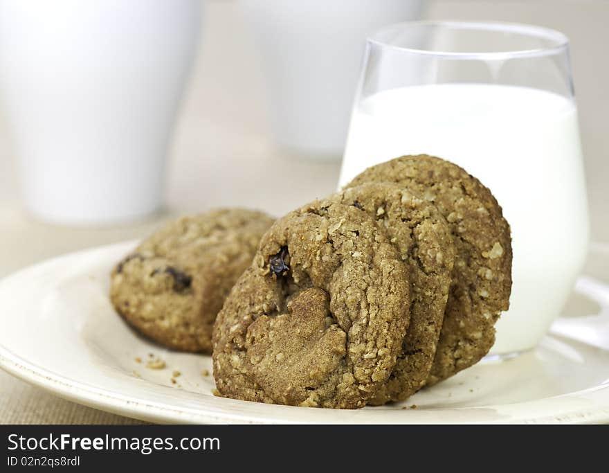 Fresh oatmeal raisin cookies and a glass of milk. Fresh oatmeal raisin cookies and a glass of milk