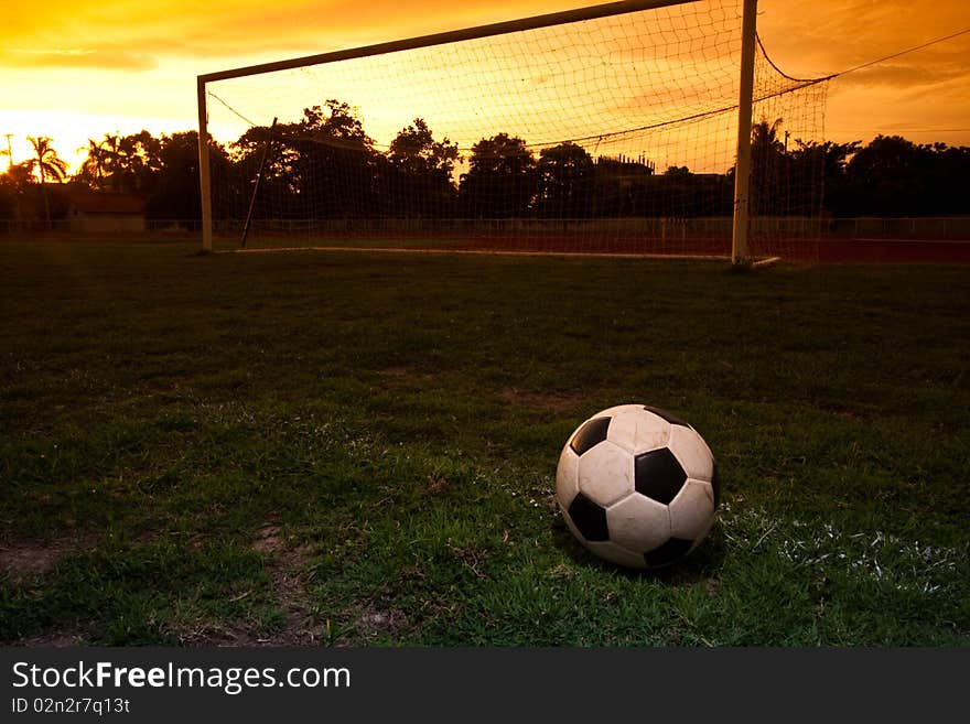 One football on the ground with sunset. One football on the ground with sunset