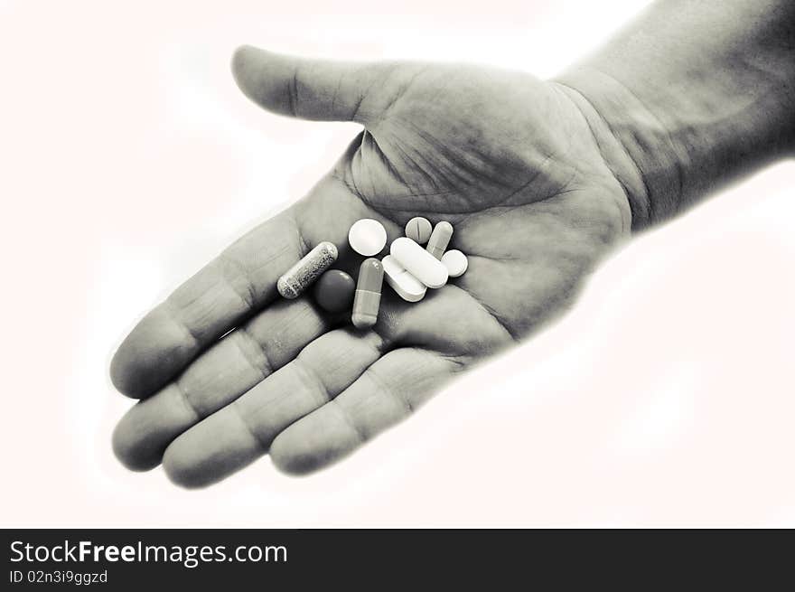 Hand in black and white holding pills isolated on white. Hand in black and white holding pills isolated on white