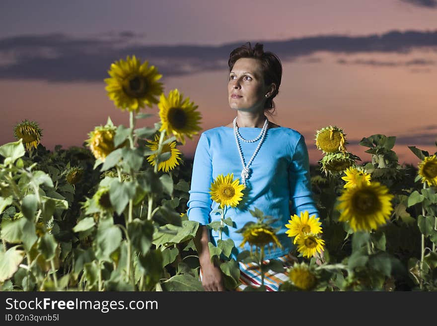 Damsel in sunflower field illuminated with flash