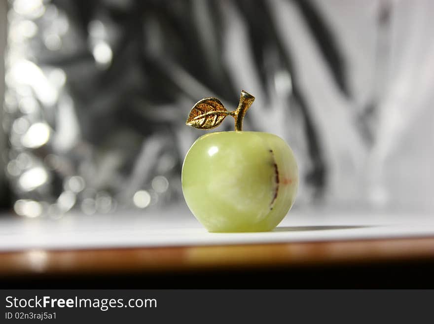 Green artificial apple on the metal background