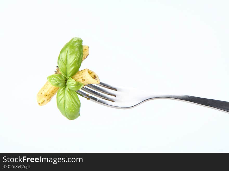 Penne with pesto on a fork