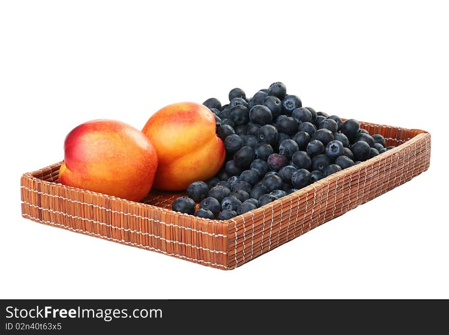 Berries of a blueberry and nectarine in a deep wattled tray. Berries of a blueberry and nectarine in a deep wattled tray.