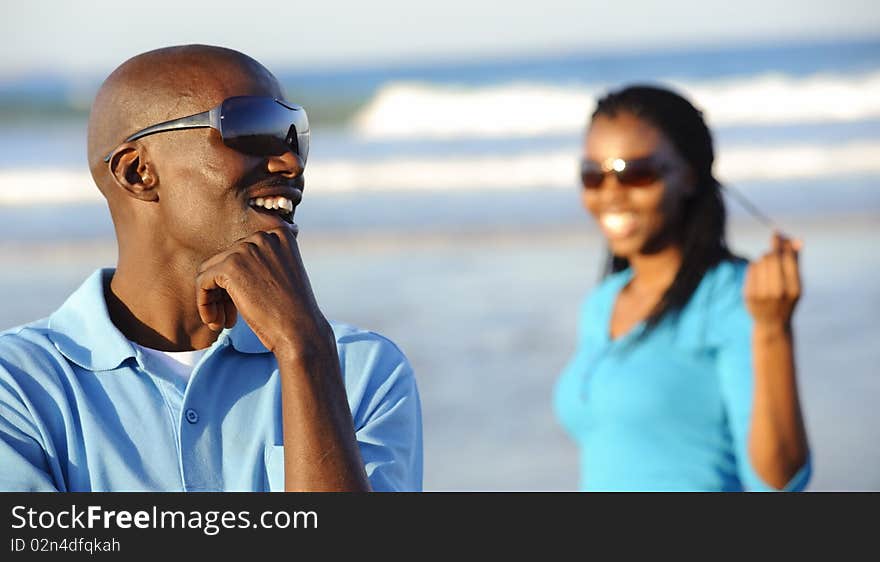 African man is laughing at his girlfriend in the background. African man is laughing at his girlfriend in the background