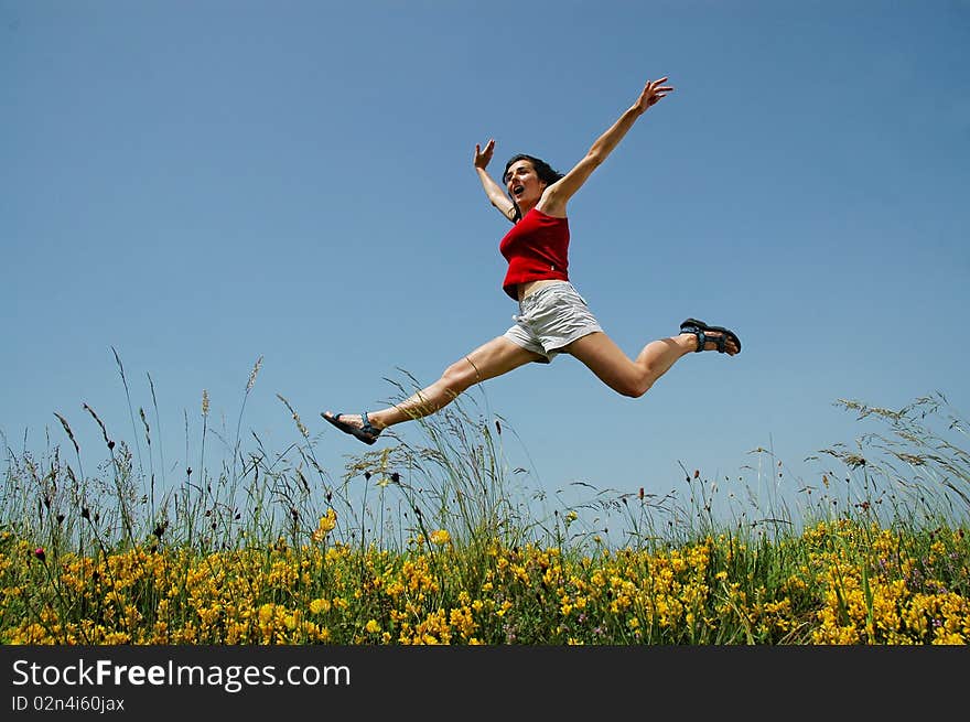 Beautiful young girl jumping in a meadow