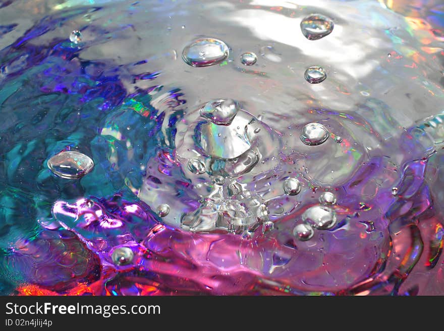 Water bubbles from a faucet with a bold metallic backdrop. Water bubbles from a faucet with a bold metallic backdrop.