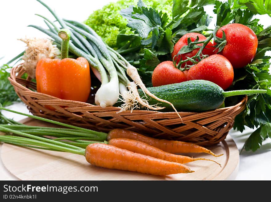 Organic vegetables in basket on white background