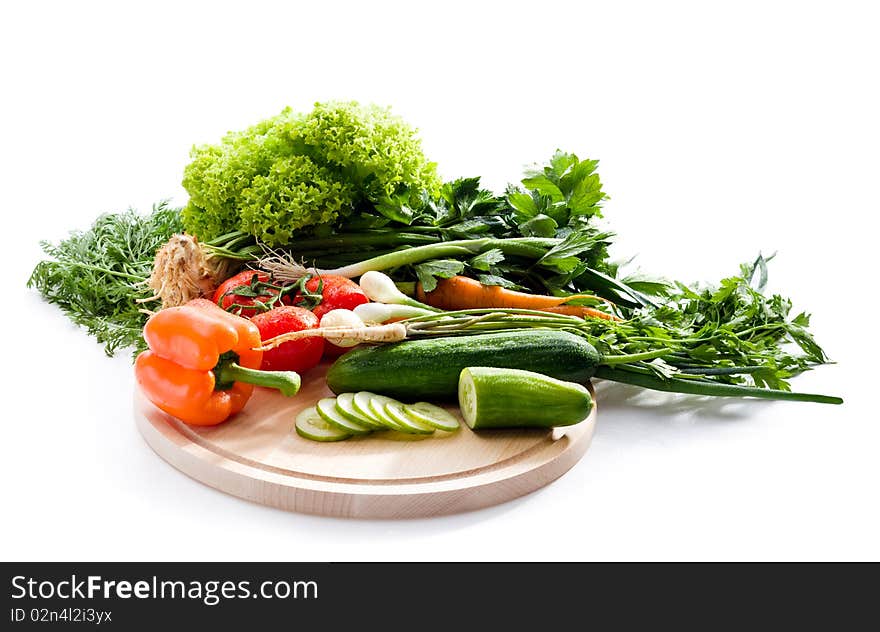 Raw vegetables on cutting board on white background