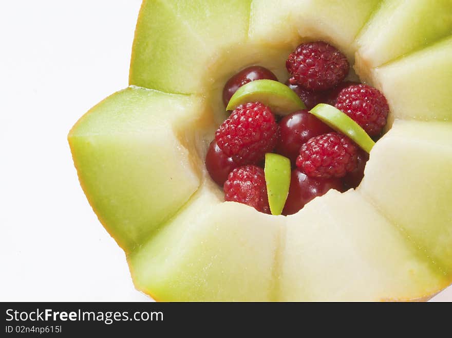 Half melon in zigzag with different fruits isolated over white background. Half melon in zigzag with different fruits isolated over white background