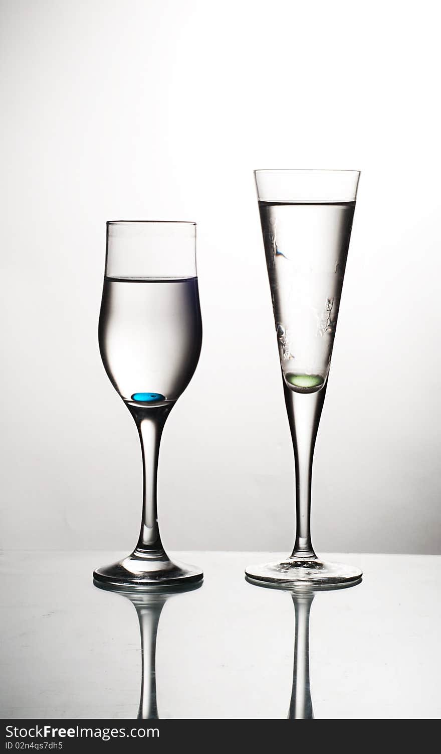 Two glasses on glass table water