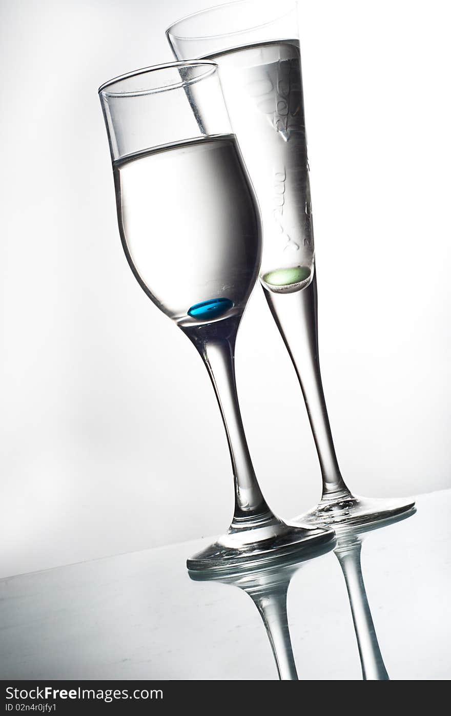 Two glasses on glass table