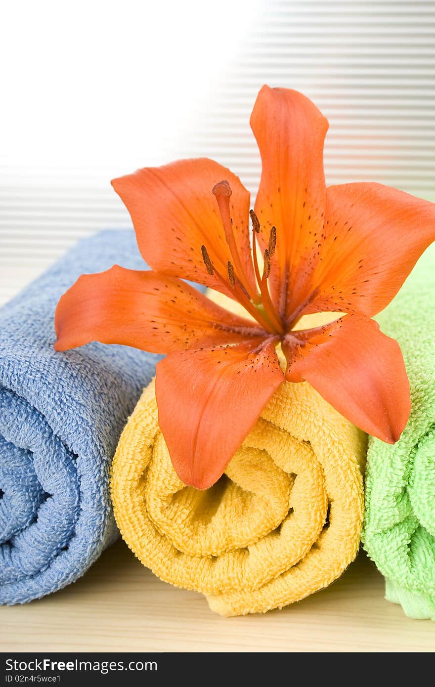 Colored towels are folded to lie next to them flower tiger lily. Colored towels are folded to lie next to them flower tiger lily