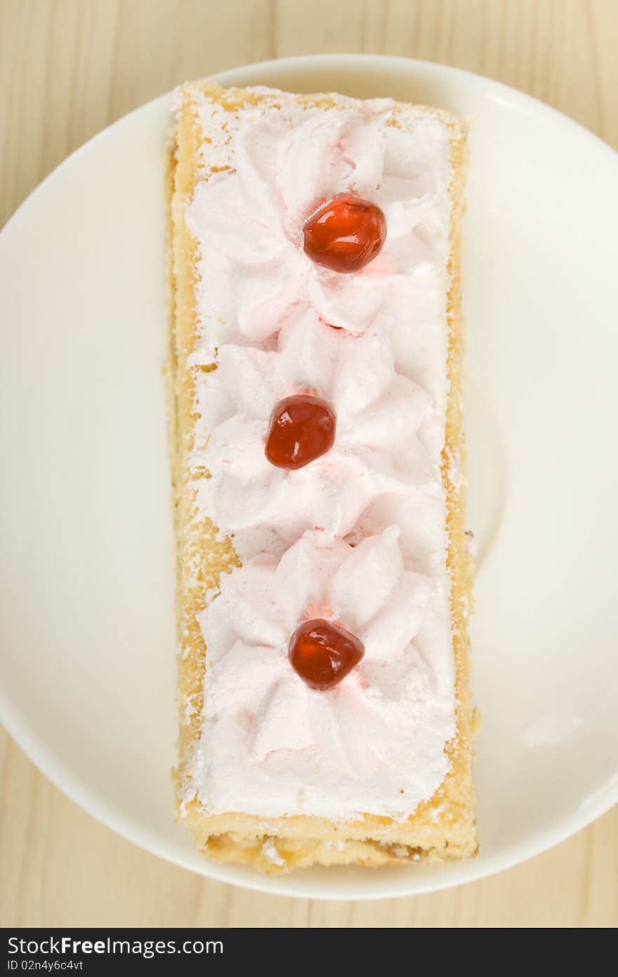 On the table a plate with a pink cake