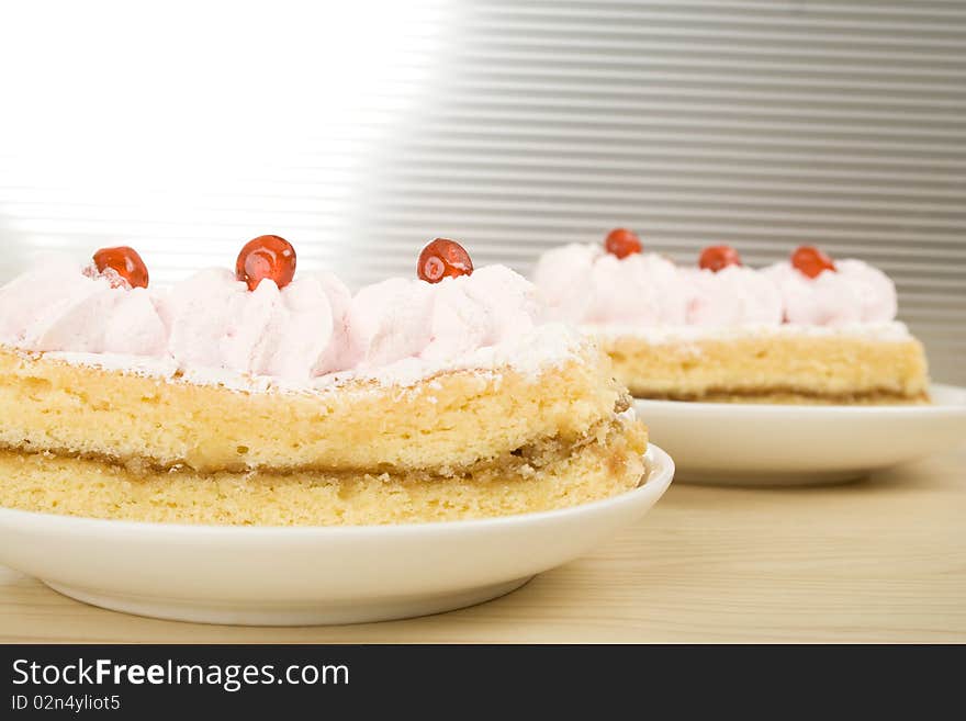 On the table a plate with a pink cake