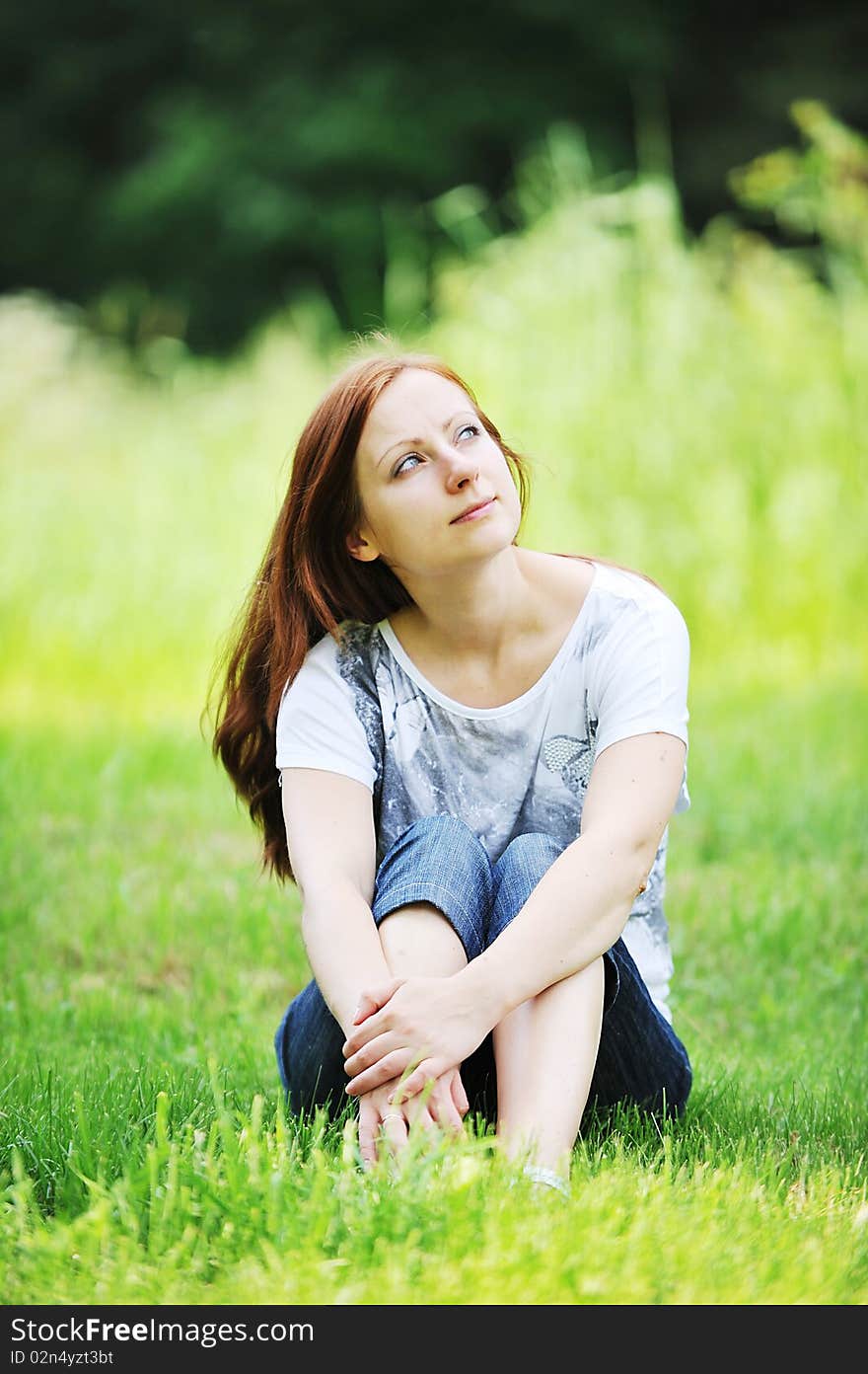 Young woman relaxing on green grass