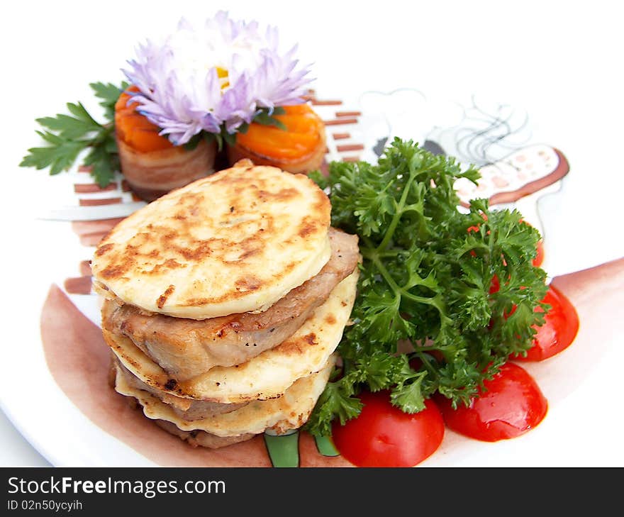 The ornament plate with medallions from pork with flat cakes from vegetable marrow under teriyaki sauce. The ornament plate with medallions from pork with flat cakes from vegetable marrow under teriyaki sauce.