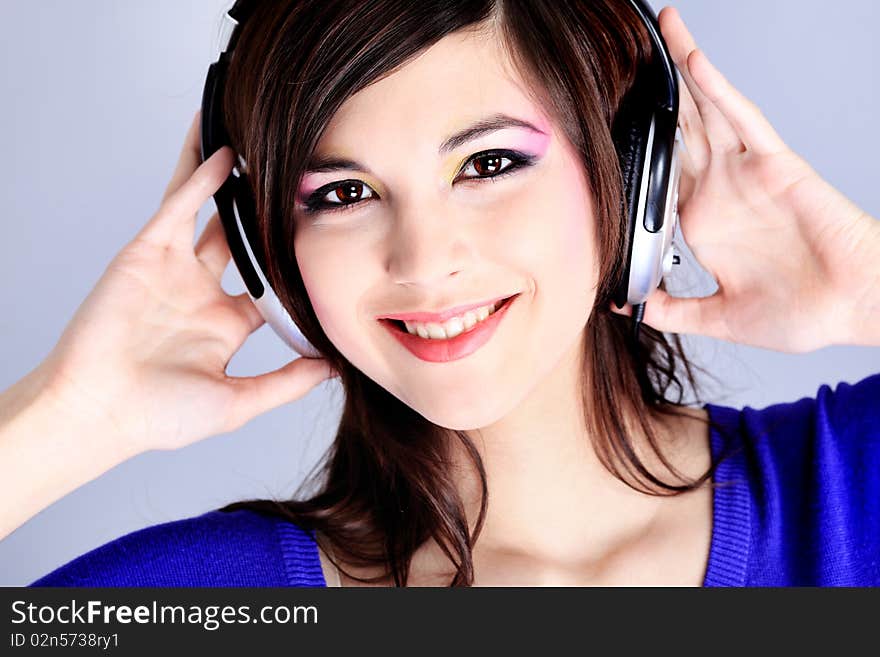 Shot of a pretty young woman in headphones listening to music with pleasure. Shot in a studio. Shot of a pretty young woman in headphones listening to music with pleasure. Shot in a studio.