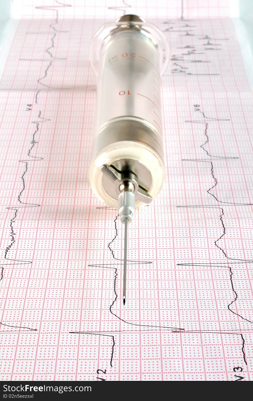 Old glass syringe on the cardiogram tape