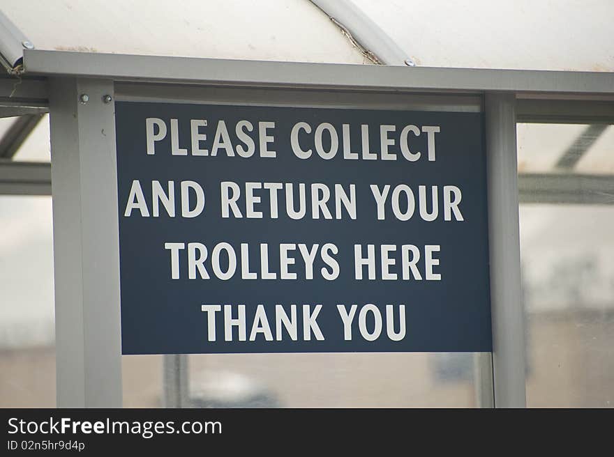 An image of a sign board in a supermarket car park indicating  the collection and return point for shopping trolleys. An image of a sign board in a supermarket car park indicating  the collection and return point for shopping trolleys.