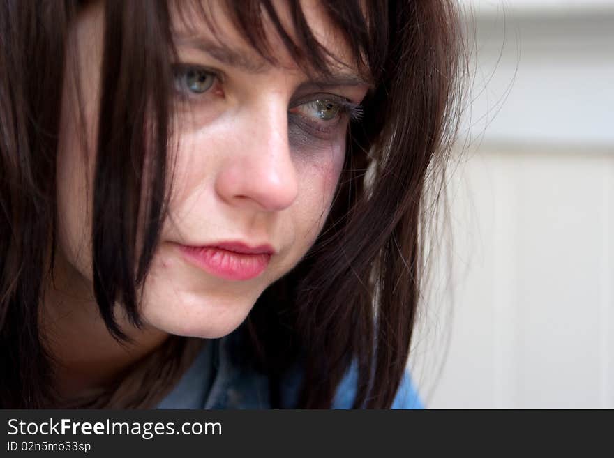 Young woman with black-eye crying