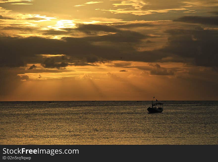 Golden sunset at sea with silhouette of a boat. Golden sunset at sea with silhouette of a boat