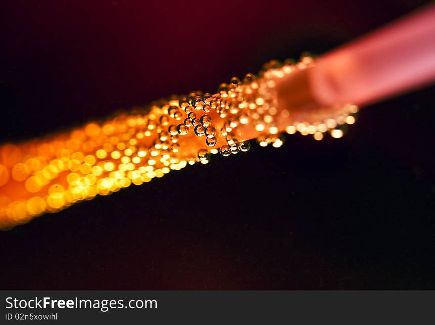 Straw in detail in a glass with red background