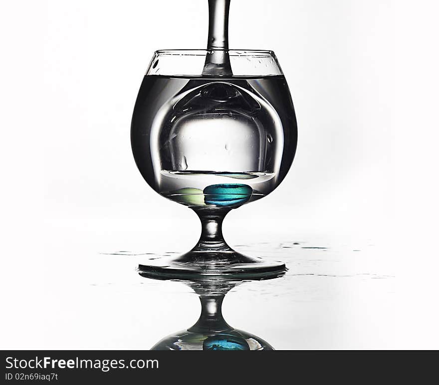 Glass in glass with water and pills
