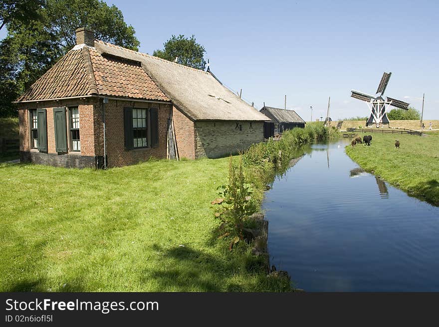 Old house vith canal and windmill. Old house vith canal and windmill