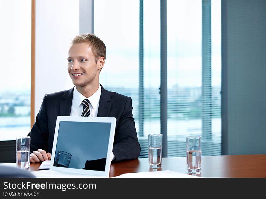 The young man in a suit with the laptop at office. The young man in a suit with the laptop at office