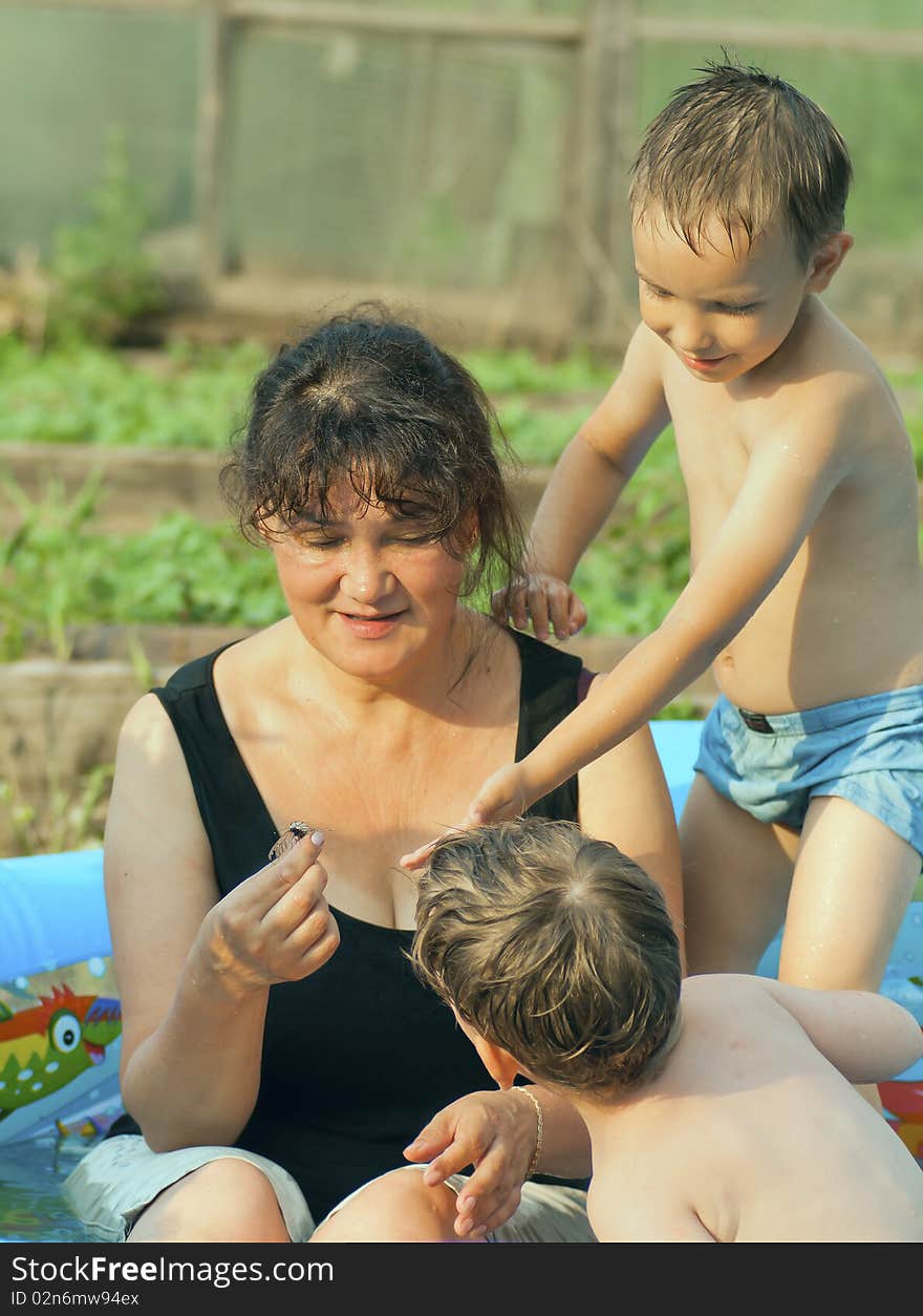 The grandmother and grandsons have a rest in pool