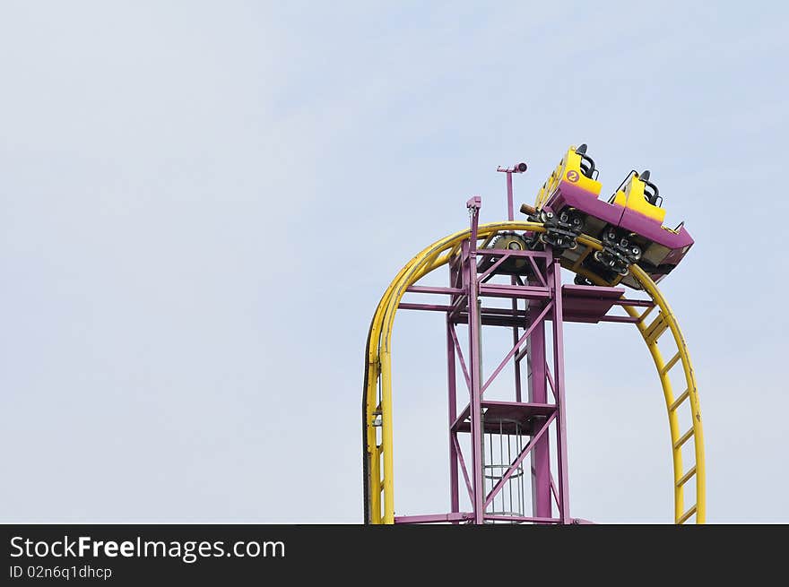 Having fun in park witk rollercoaster, blue sky in background. Having fun in park witk rollercoaster, blue sky in background