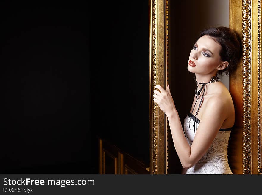 The beautiful girl with a make-up at a gold door