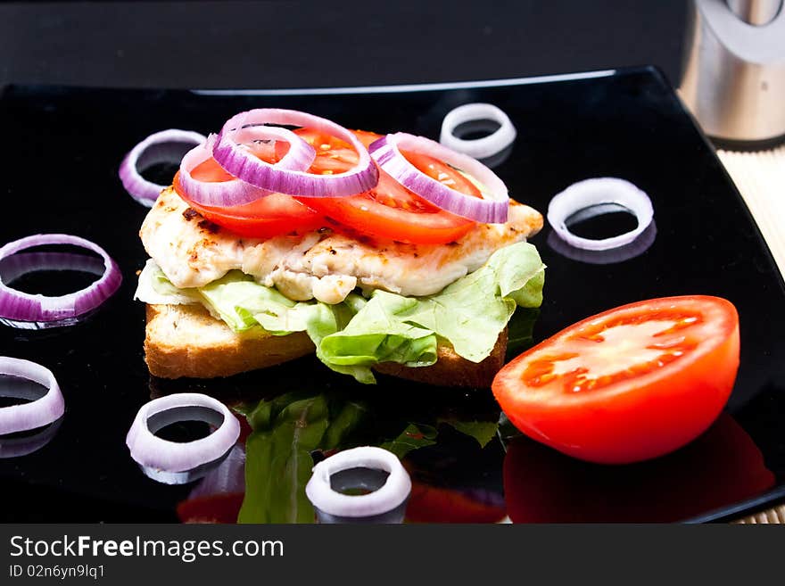 Chicken sandwich on a black plate