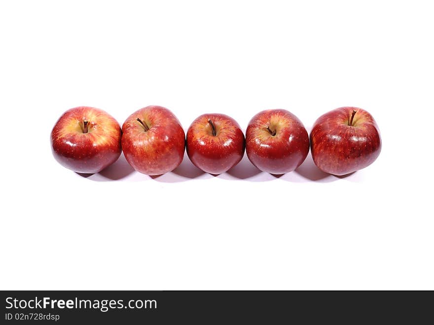 Apples in a row on white with natural shadow.