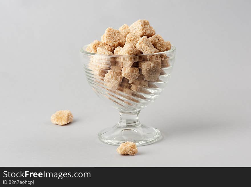 Cane sugar cubes isolated on a gray background