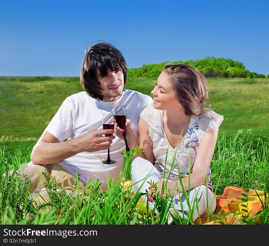 Girl and boy with wineglasses on grass