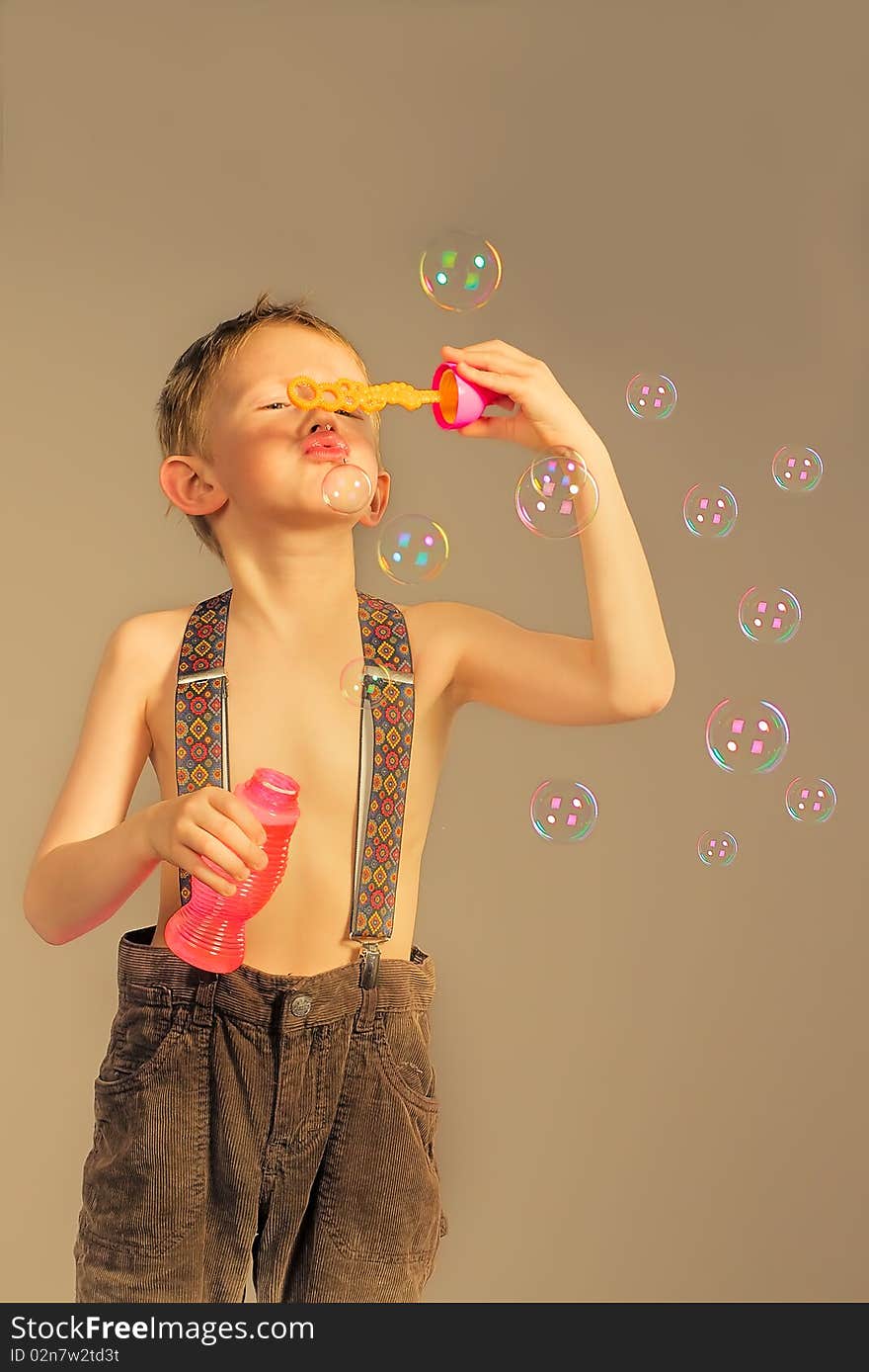 The little boy inflates soap bubbles