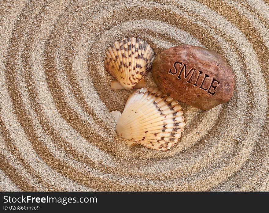 Conceptual image with seashells and a smile stone on sand. Conceptual image with seashells and a smile stone on sand