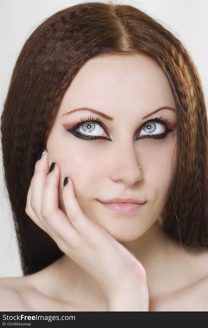 Close-up portrait of a young, beautiful caucasian woman with black nail polish and dark make-up