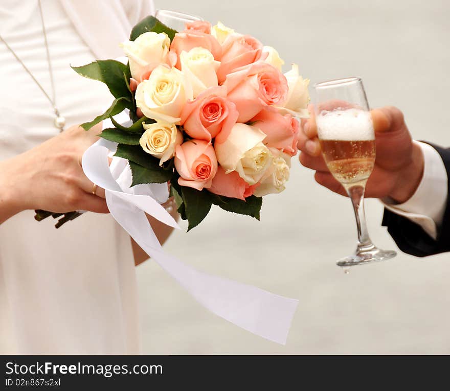 Glass of champagne in a hand of the groom,flower in the hands of the bride. Glass of champagne in a hand of the groom,flower in the hands of the bride