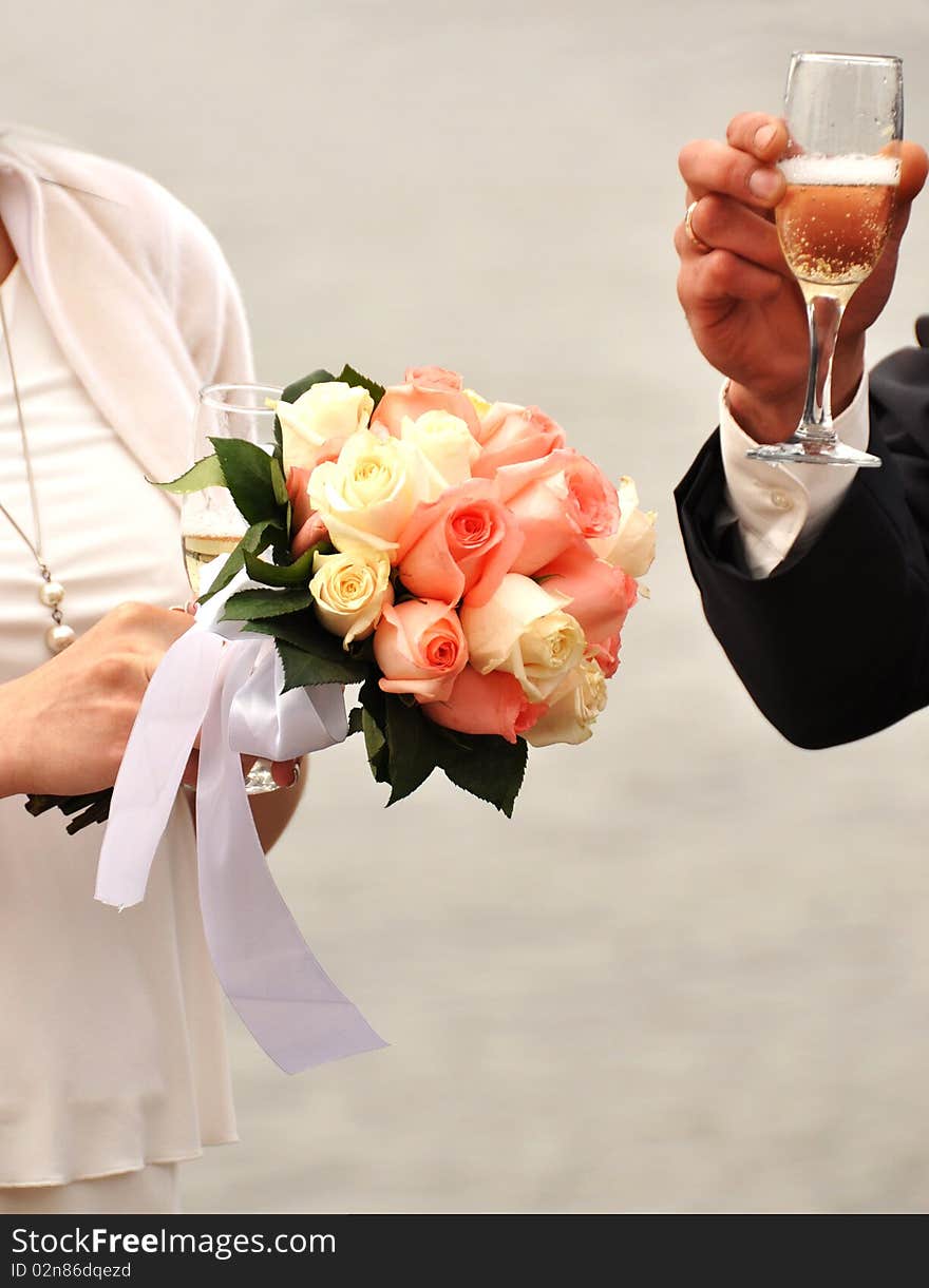 Glass of champagne in a hand of the groom,flower in the hands of the bride. Glass of champagne in a hand of the groom,flower in the hands of the bride