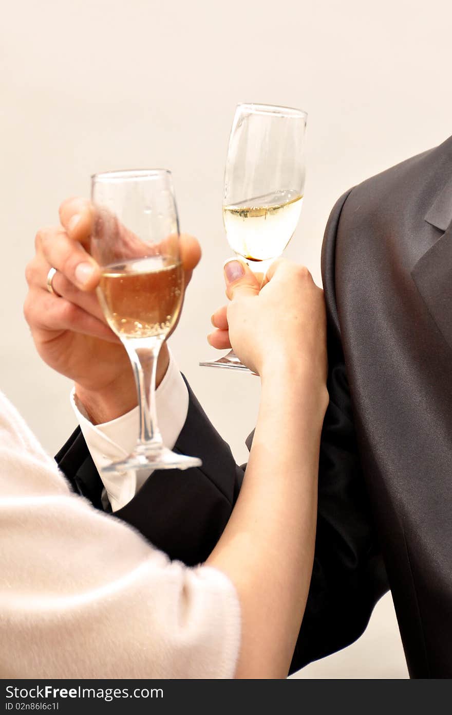 Image of two glasses of champagne in the hand on gray background