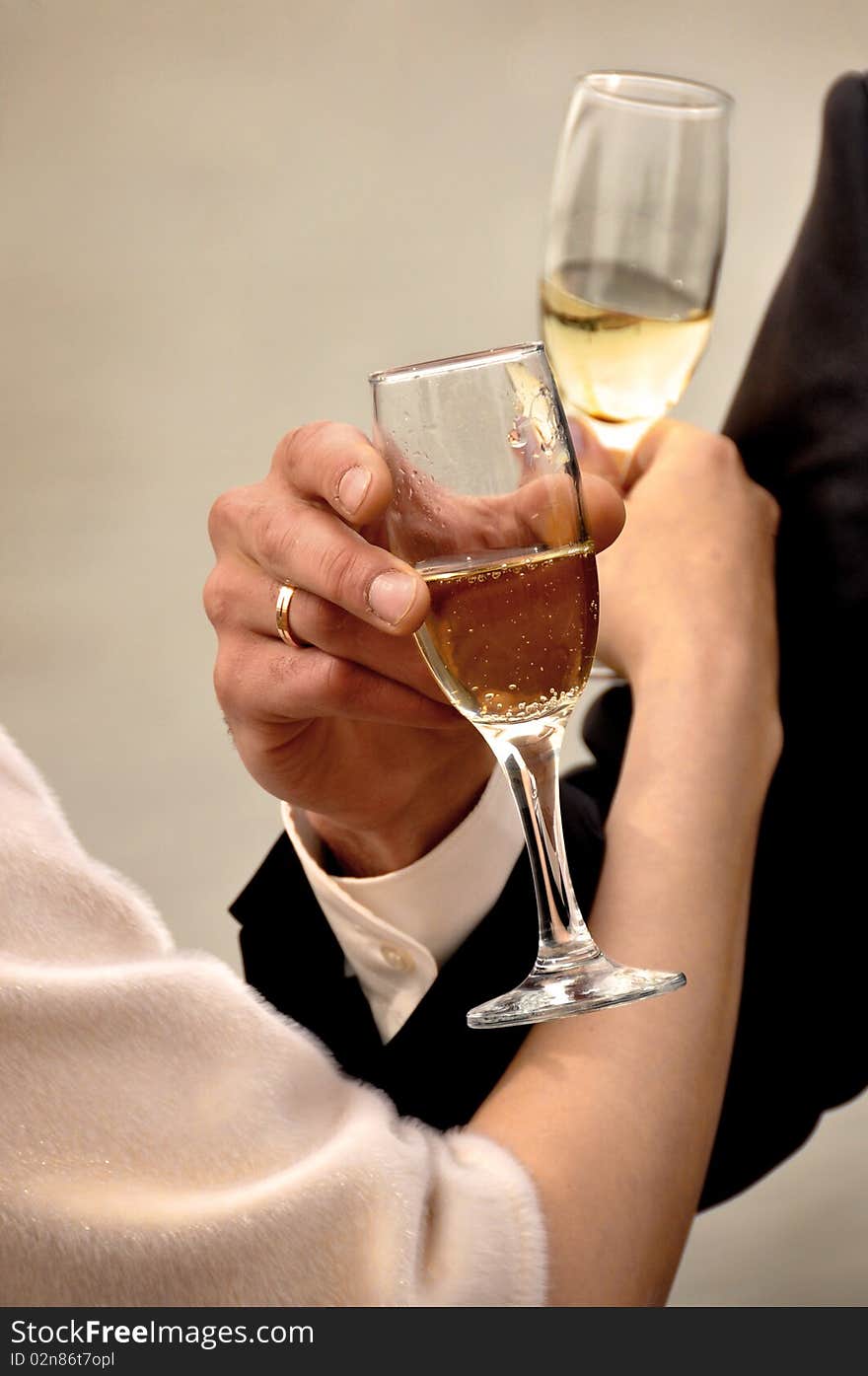 Image of two glasses of champagne in the hand on gray background