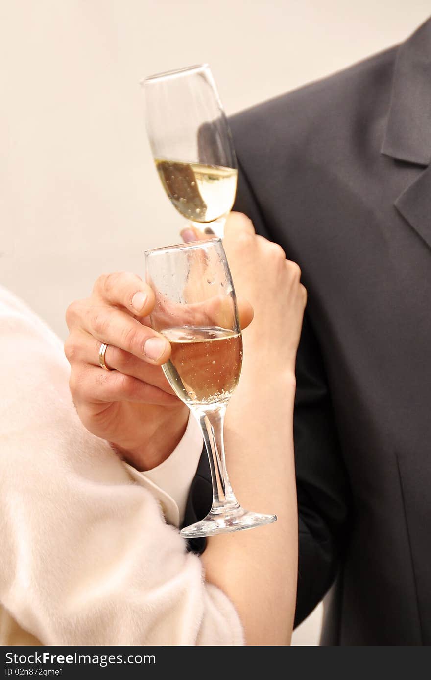 Image of two glasses of champagne in the hand on gray background