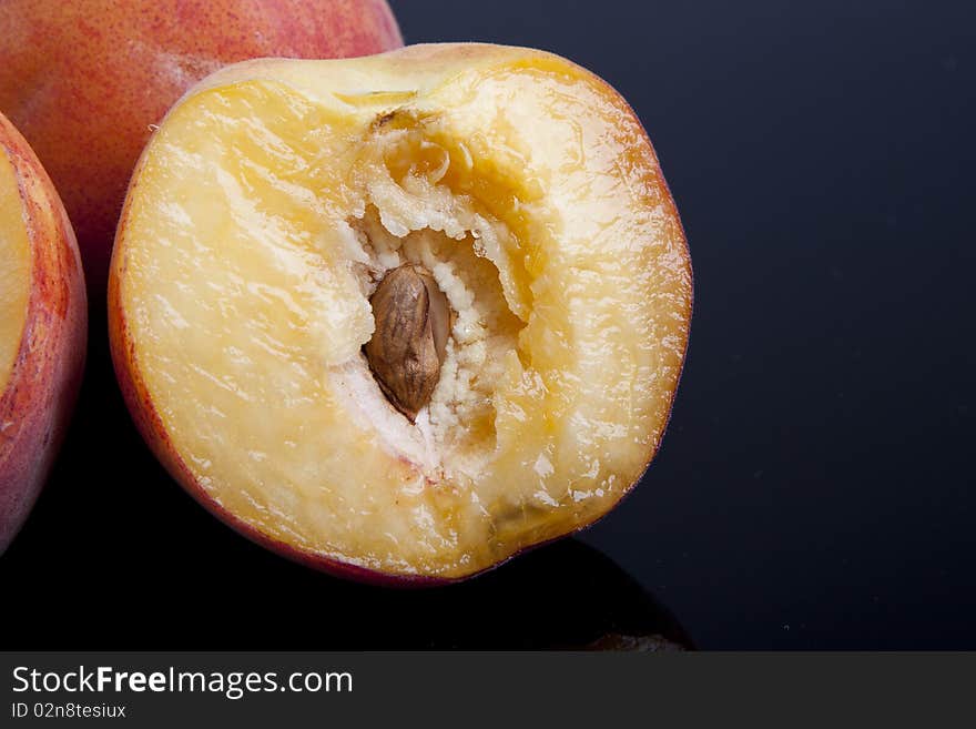 Detail of a sliced peach over a black. Detail of a sliced peach over a black