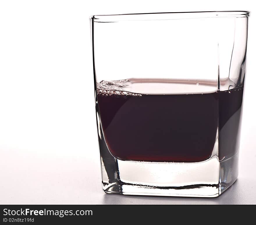 Glass of red drink isolated over white background.