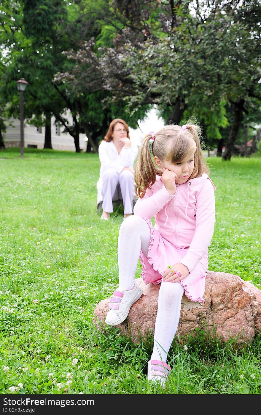 Girl and mother sitting on rocks in nature. Girl and mother sitting on rocks in nature